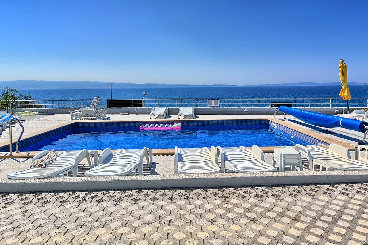 Shared pool and sun loungers overlooking the Adriatic